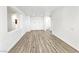 Open living room with modern wood flooring, white walls, and arched doorways at 3829 N Mayfield Ranch Rd, Pahrump, NV 89060