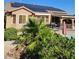 Backyard featuring a covered patio, solar panels, and lush greenery, offering a serene outdoor space at 4016 Mountain Trek St, Las Vegas, NV 89129