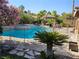 Backyard oasis featuring a sparkling pool, a relaxing spa, lush landscaping, and a charming tiki hut at 4016 Mountain Trek St, Las Vegas, NV 89129