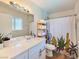 Well-lit bathroom featuring a white vanity, quartz countertop, decorative shower curtain, and ample storage at 4072 E Harmon Ave, Las Vegas, NV 89121