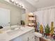 Bright bathroom featuring a white vanity, quartz countertop, decorative shower curtain, and ample storage at 4072 E Harmon Ave, Las Vegas, NV 89121