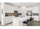 Modern kitchen featuring stainless steel appliances, white cabinetry, island with barstool seating and patterned backsplash at 41 Strada Moscato, Henderson, NV 89011