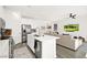 Open concept kitchen view showcasing an island with a sink, stainless steel appliances, and a view of the living room at 41 Strada Moscato, Henderson, NV 89011