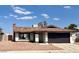 Single-story home featuring a brick chimney, gravel landscaping, and an attached two-car garage at 4276 Aspen St, Las Vegas, NV 89147