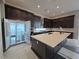 Well-lit kitchen with a large island, custom cabinetry, and a full-size refrigerator at 4750 Outlook Peak St, Las Vegas, NV 89135