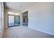 Carpeted living room features a sliding glass door leading to an outdoor patio at 4750 Outlook Peak St, Las Vegas, NV 89135