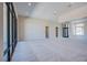 Spacious living room with plush carpeting, recessed lighting, and large windows at 4750 Outlook Peak St, Las Vegas, NV 89135