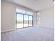 Bright living room with plush carpet and a large glass sliding door to the backyard at 4750 Outlook Peak St, Las Vegas, NV 89135
