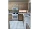 Bright kitchen features white appliances, light cabinets, white countertops and tile flooring at 495 Edgefield Ridge Pl, Henderson, NV 89012