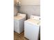 This laundry room features a washer, dryer, tile floor, and a shelf for storage at 5004 Wayfaring Tree Ave, Las Vegas, NV 89131