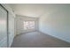 Bright bedroom with neutral carpet, closet and a window overlooking neighborhood homes at 5256 Harvest Breeze Rd, Las Vegas, NV 89118