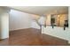 Open-concept living room featuring wood floors, staircase, and kitchen with breakfast bar, great for entertaining at 5256 Harvest Breeze Rd, Las Vegas, NV 89118