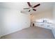 Bright loft area featuring neutral carpeting, a ceiling fan, and an open railing overlooking the floor below at 5256 Harvest Breeze Rd, Las Vegas, NV 89118