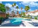 Community pool surrounded by lush palm trees, landscaping, and a sun shelter at 5256 Harvest Breeze Rd, Las Vegas, NV 89118