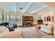 Comfortable living room featuring a stone fireplace, beamed ceiling, and neutral-toned carpeting at 5368 Regal Ave, Las Vegas, NV 89146
