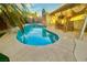 Backyard pool surrounded by concrete, palm trees, and a covered patio with vintage nautical decor at 5368 Regal Ave, Las Vegas, NV 89146