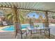 A serene pool area with covered dining and lush greenery offers relaxation and privacy at 5368 Regal Ave, Las Vegas, NV 89146