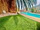 Backyard pool with artificial turf, landscaping, and a covered patio with nautical decorations at 5368 Regal Ave, Las Vegas, NV 89146