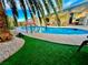 Pool with artificial turf surround, mature landscaping, and vintage nautical decorations on the covered patio at 5368 Regal Ave, Las Vegas, NV 89146