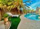 Backyard pool with a lounge chair area featuring manicured turf and a lovely potted plant at 5368 Regal Ave, Las Vegas, NV 89146