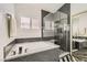 Modern bathroom featuring a soaking tub, separate shower, and granite counters at 5489 Royal Vista Ln, Las Vegas, NV 89149