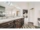 Modern bathroom with dual vanities, granite counters, and tile floors with a view of tub and shower at 5489 Royal Vista Ln, Las Vegas, NV 89149