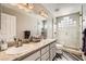 Bathroom showcasing dual sinks, granite countertop, and glass-enclosed shower at 5489 Royal Vista Ln, Las Vegas, NV 89149