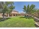 Lush backyard featuring a covered patio, large manicured lawn, mature trees, and an inviting swimming pool at 6103 Sundown Crest St, Las Vegas, NV 89113