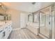 Bright bathroom with a soaking tub, glass shower, and dual sink vanity, and white tiled finishes at 6103 Sundown Crest St, Las Vegas, NV 89113
