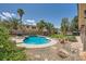 Lush landscaped backyard featuring a pool, spa, palm trees and rock features and patio at 6103 Sundown Crest St, Las Vegas, NV 89113