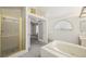Bright bathroom featuring a soaking tub, separate glass shower, and french doors to a room at 615 Cervantes Dr, Henderson, NV 89014