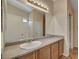 Bathroom features a large mirror, light fixture, solid surface vanity, and wood-look flooring at 6241 Overhang Ave, Henderson, NV 89011