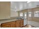 An open kitchen featuring wood cabinets, neutral countertops, and a stainless steel sink with views to the living room at 6241 Overhang Ave, Henderson, NV 89011