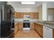 Well-equipped kitchen featuring wood cabinets, stone-look countertops, and modern white appliances at 6241 Overhang Ave, Henderson, NV 89011