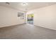Bright living room featuring neutral paint, carpeting, and sliding doors to the backyard at 6360 Bullring Ln, Las Vegas, NV 89130