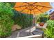 Inviting backyard patio with comfortable seating, lush greenery, and a shade umbrella at 6810 Silver Crescent St, Las Vegas, NV 89148