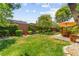 Well-manicured backyard features mature trees, patio seating, and lush green lawn at 6810 Silver Crescent St, Las Vegas, NV 89148