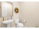 Bright half-bathroom features a modern sink, toilet, and decorative wall wreath at 6810 Silver Crescent St, Las Vegas, NV 89148