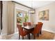 Bright dining area with modern chandelier and sliding glass doors opening to outdoor greenery at 6810 Silver Crescent St, Las Vegas, NV 89148