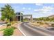 Community entrance with stone accents, mature landscaping, and paved road at 6810 Silver Crescent St, Las Vegas, NV 89148