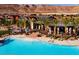 A resort-style pool is surrounded by lush landscaping, mountain views, and comfortable lounge areas at 6810 Silver Crescent St, Las Vegas, NV 89148