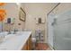Well-lit bathroom featuring a single sink, framed mirror, and shower with sliding glass door at 7817 Homing Pigeon St, North Las Vegas, NV 89084