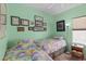 Bright bedroom with two twin beds, colorful bedding, neutral floors and light-green painted walls at 7817 Homing Pigeon St, North Las Vegas, NV 89084