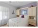 Bedroom with a built in headboard, cabinets, and dresser beside a bright window at 7817 Homing Pigeon St, North Las Vegas, NV 89084