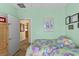 Light-green bedroom featuring twin beds, neutral flooring, and artwork hung on the wall at 7817 Homing Pigeon St, North Las Vegas, NV 89084