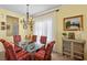 Bright dining area features a glass top table, decorative chairs, and a chandelier for elegant meals at 7817 Homing Pigeon St, North Las Vegas, NV 89084