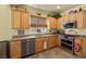 Well-equipped kitchen with stainless steel appliances, granite countertops, and natural wood cabinetry at 7817 Homing Pigeon St, North Las Vegas, NV 89084