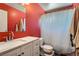 Bathroom featuring a white vanity, red walls, and a shower tub at 7898 Wishing Well Rd, Las Vegas, NV 89123
