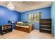 Bright bedroom with blue walls, hardwood floors, and ample natural light at 7898 Wishing Well Rd, Las Vegas, NV 89123