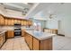 Open kitchen with light wood cabinets, stainless steel appliances, tile counters, and an island at 7898 Wishing Well Rd, Las Vegas, NV 89123